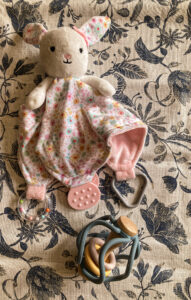 baby toy bunny and rattle lying on table for kids easter basket