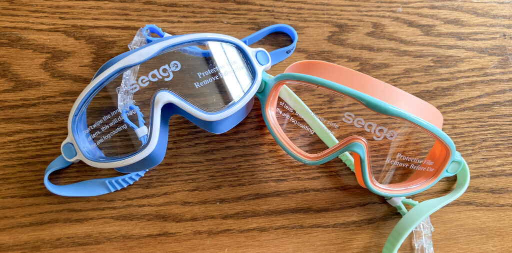 two pairs of swim goggles on table