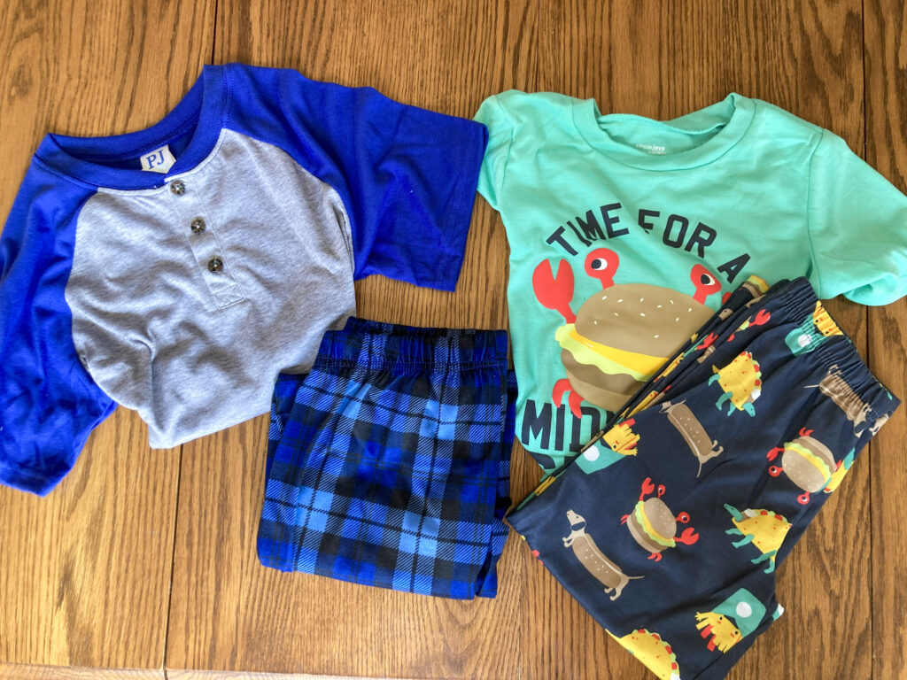 two pairs of boys pajamas on table