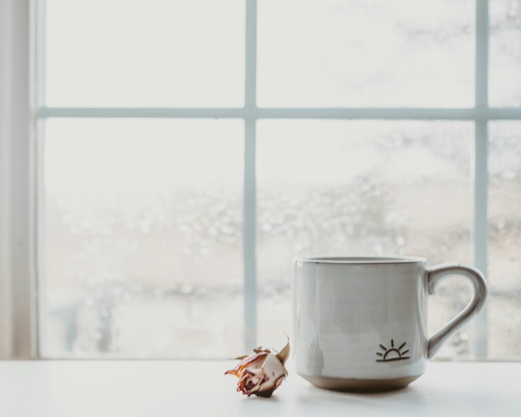 white mug on a counter in front of a window during a morning routine