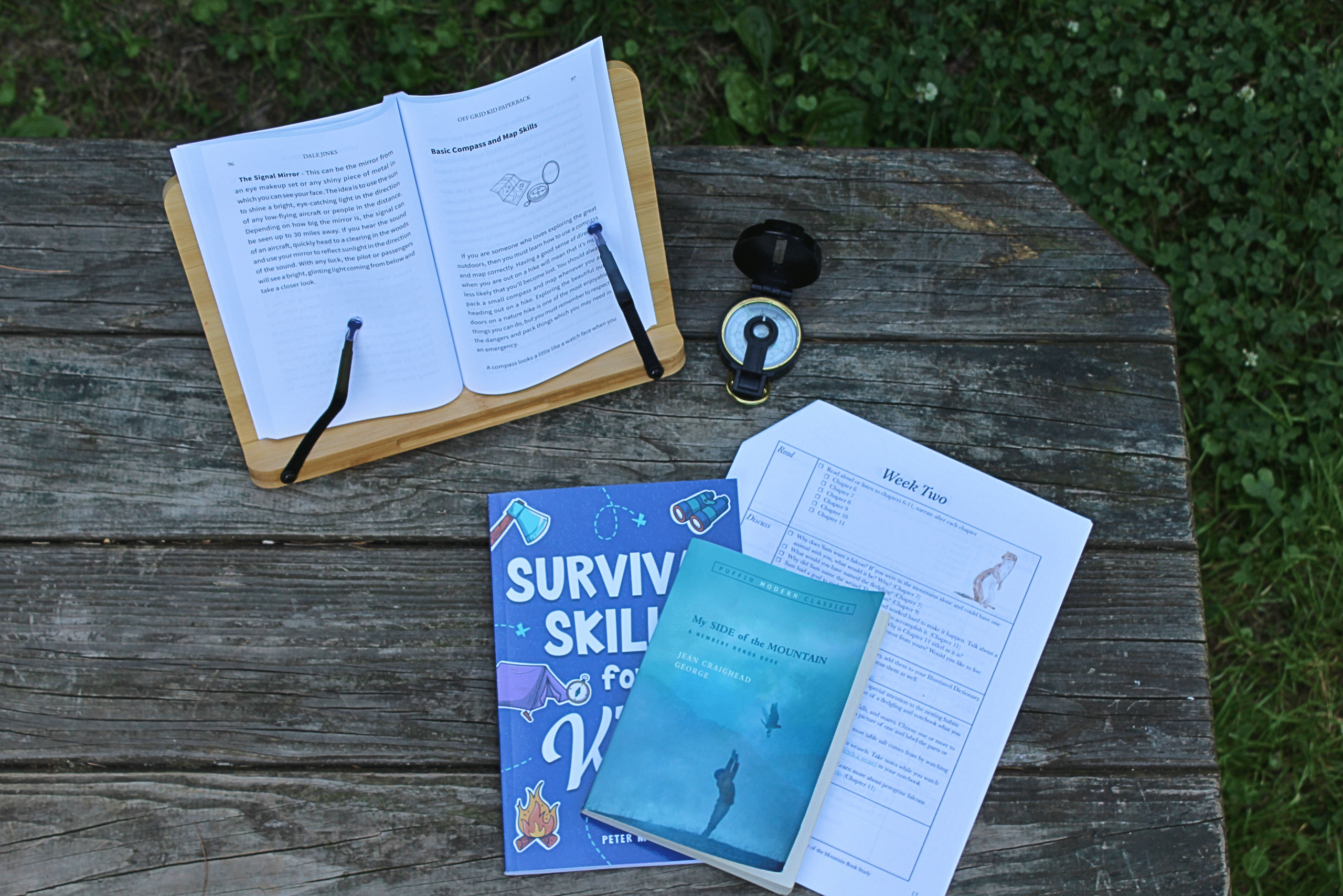Book study materials placed on a picnic table with a compass