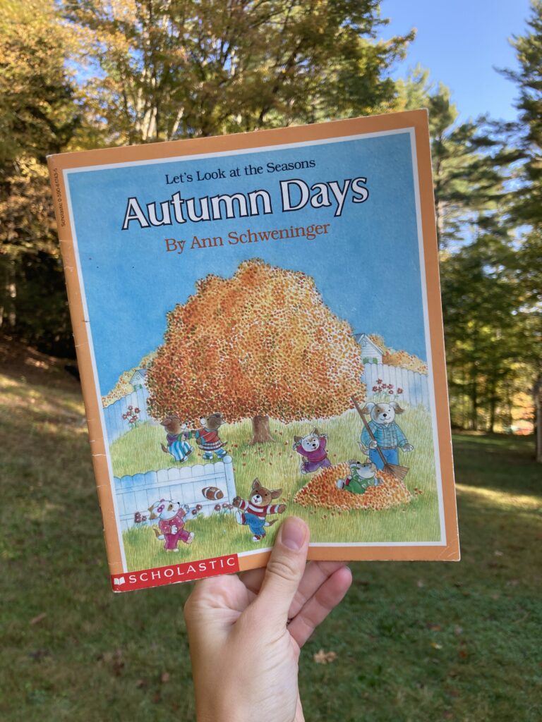 Hand holding up the book called Autumn Days