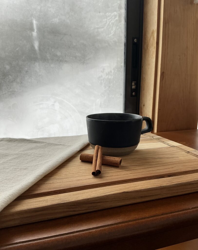 Cup of hot vanilla chai set on a table in front of a frosty window
